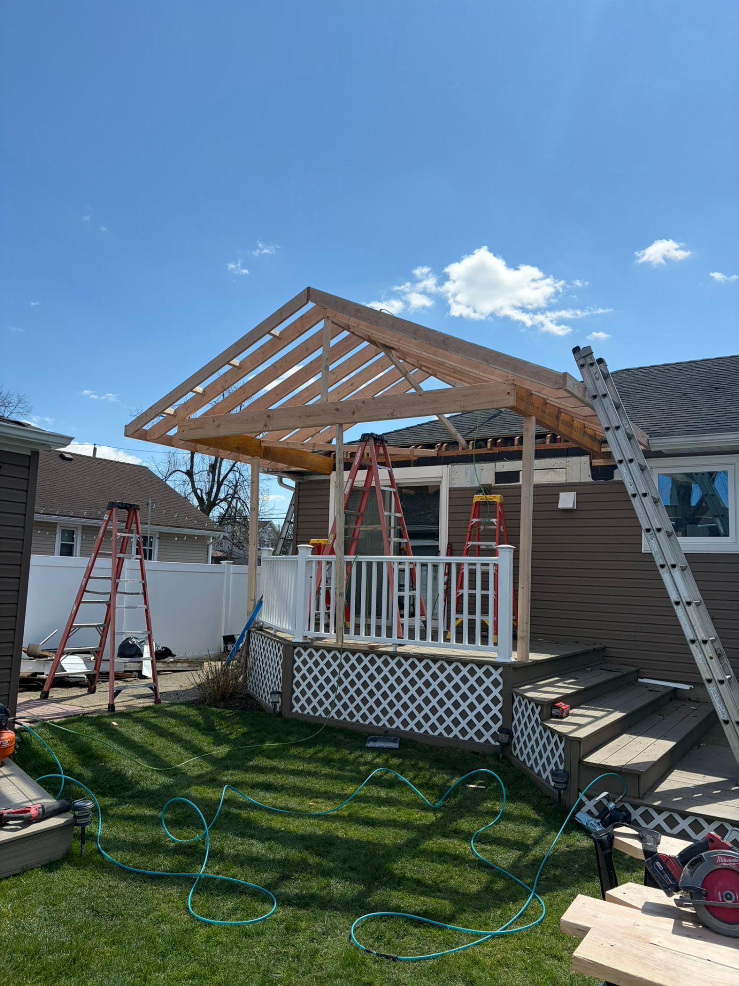 Covered deck roof framed over a backyard deck