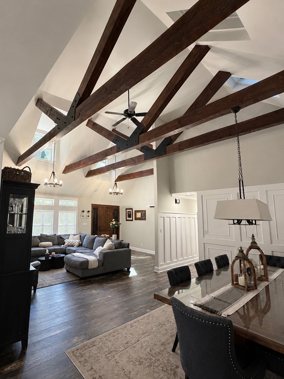 Interior remodel with vaulted ceiling, exposed timber beams, and open living and dining space