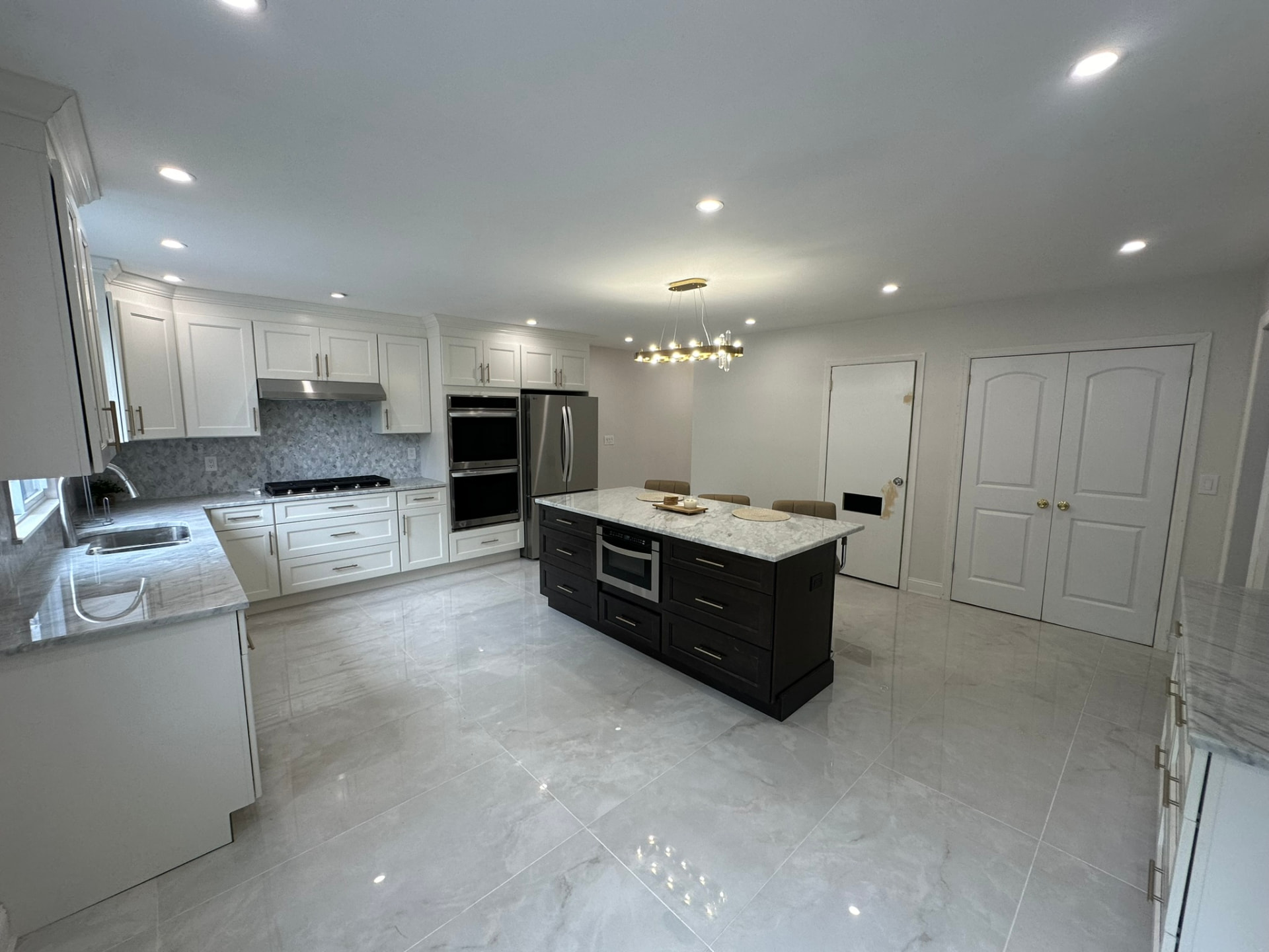 Bright white kitchen remodel with double ovens and large island