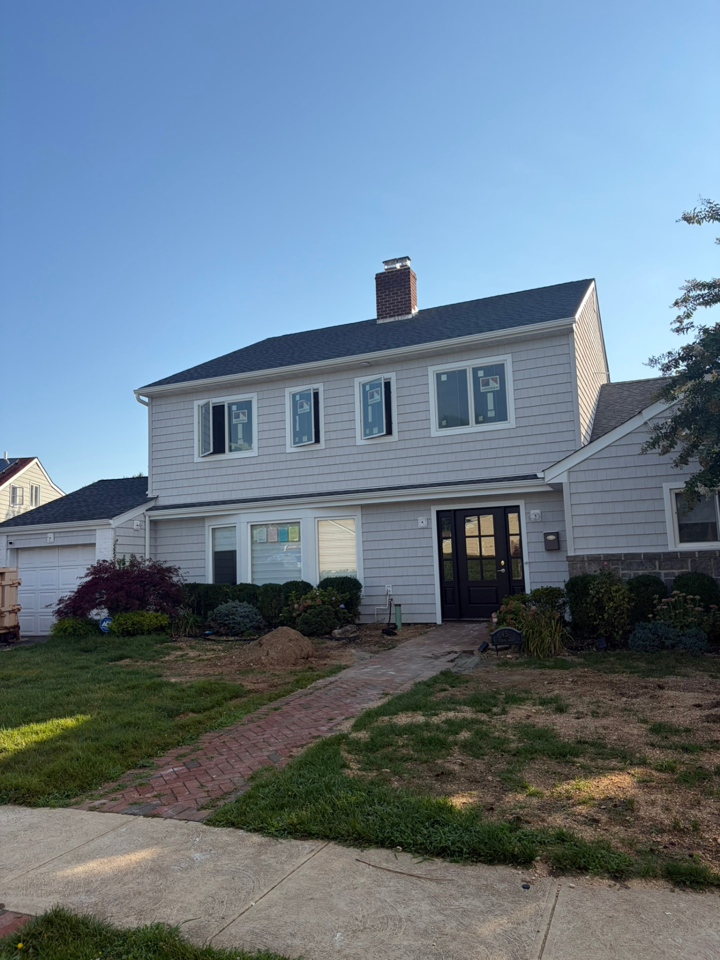 Second-story addition with light gray siding and new roof