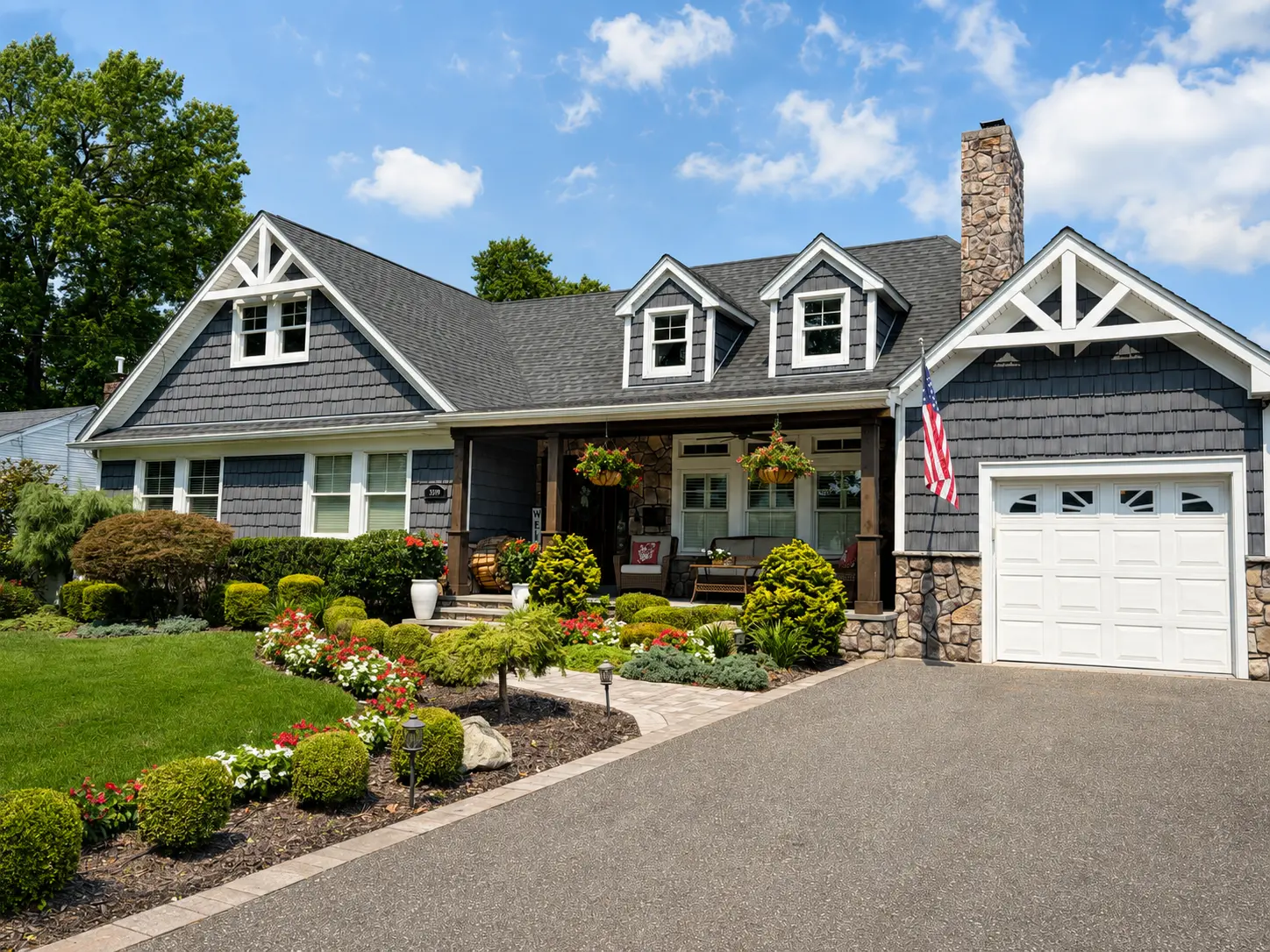 Beautifully landscaped Long Island home with dormers and stone accents