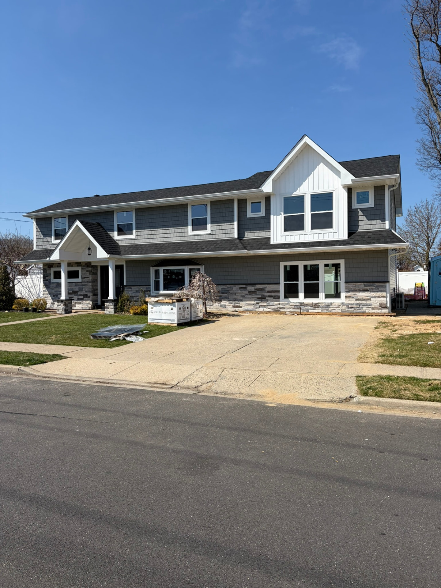 Full dormer and extension with stone accents and portico entry