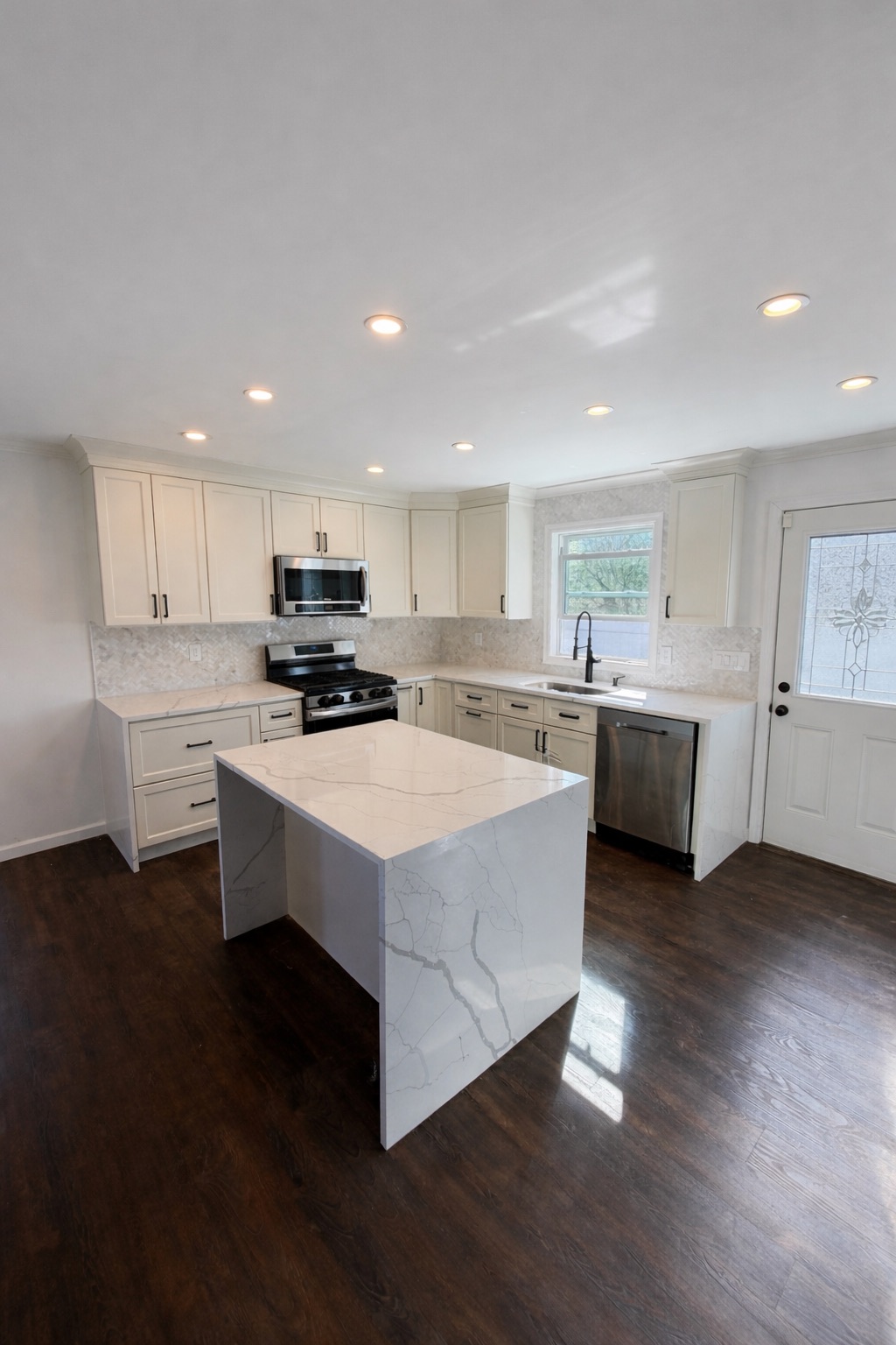 Kitchen remodel with waterfall island and white shaker cabinets