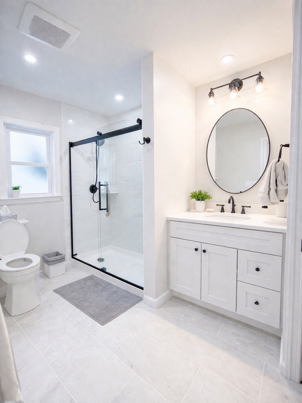 Bright white bathroom with glass shower and round mirror